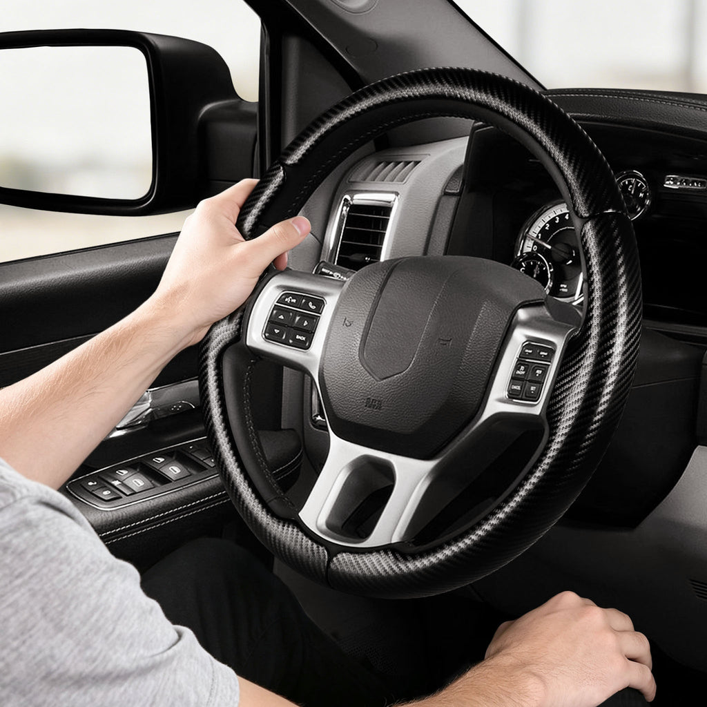 Installed view of matte black carbon-fiber-style 3-piece steering wheel cover for Dodge Ram 1500/2500/3500/4500/5500 2012-2018 & RAM 1500 Classic 2019-2023 with driver holding the wheel#color=matte black