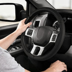 Installed view of black perforated leather 3-piece steering wheel cover for Dodge Ram 1500/2500/3500/4500/5500 2012-2018 & RAM 1500 Classic 2019-2023 with driver holding the wheel#color=black perforated leather