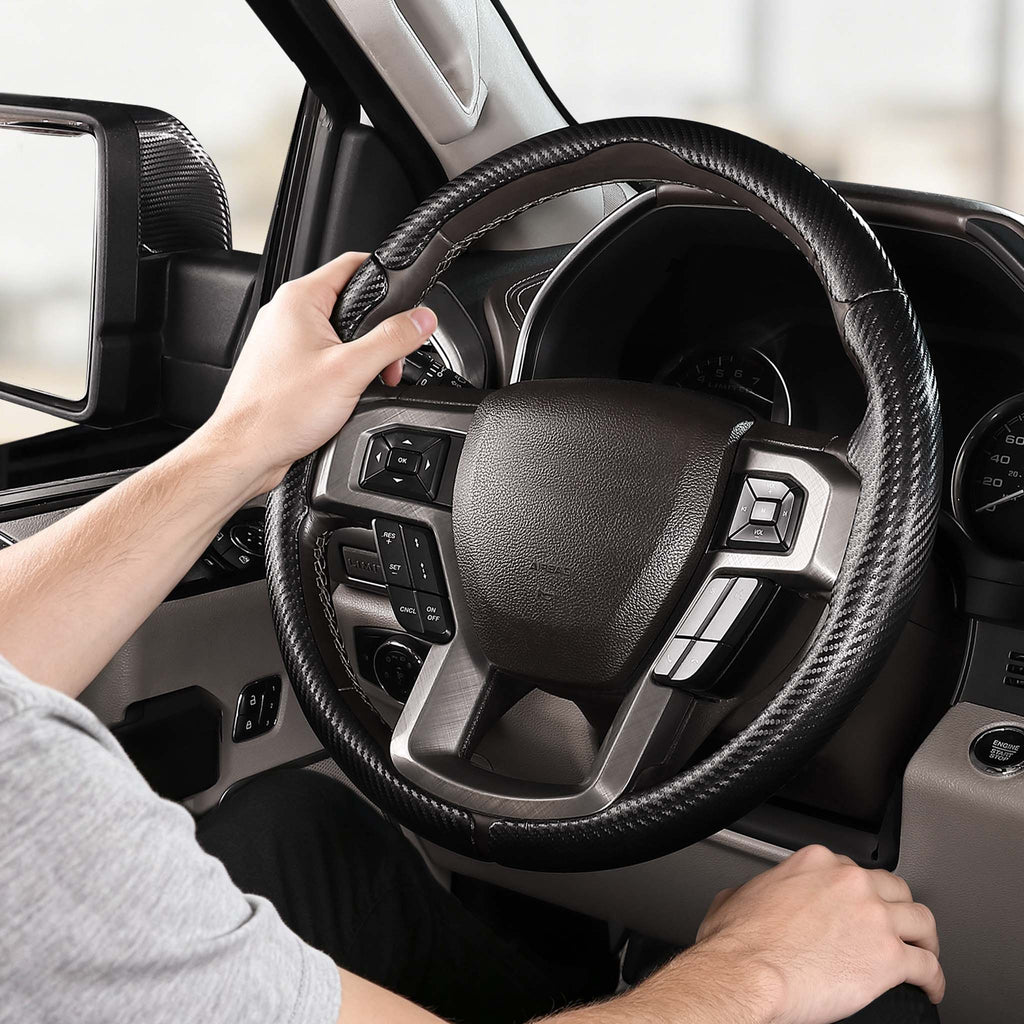 Installed view of matte black carbon-fiber-style 3-piece steering wheel cover for Ford F-150 2015-2020 & F-250/F-350/F-450/F-550 2017-2021 with driver holding the wheel#color=matte black