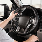 Installed view of matte black carbon-fiber-style 3-piece steering wheel cover for Ford F-150 2015-2020 & F-250/F-350/F-450/F-550 2017-2021 with driver holding the wheel#color=matte black