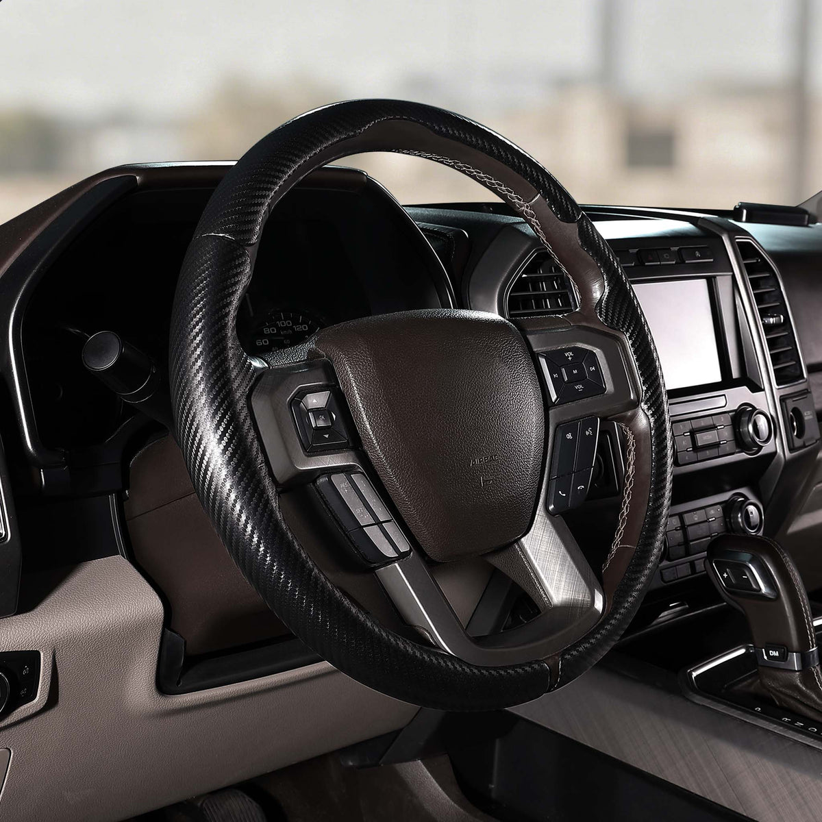 Angled installed view of matte black carbon-fiber-style 3-piece steering wheel cover for Ford F-150 2015-2020