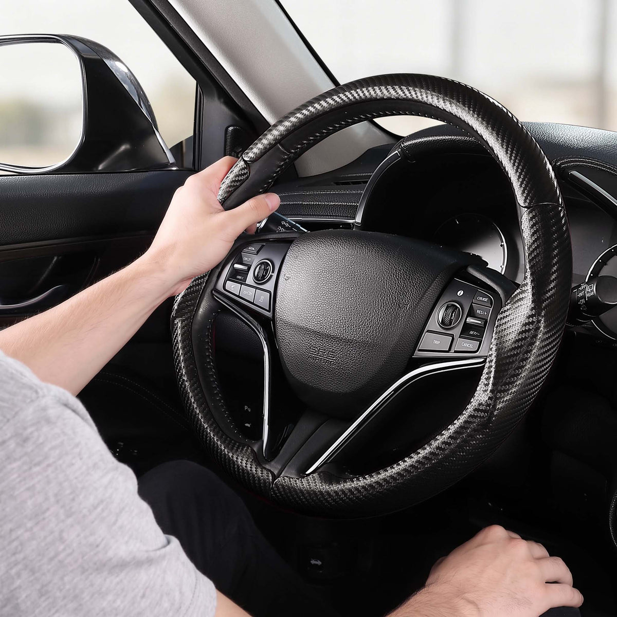 Installed view of matte black carbon-fiber-style 3-piece steering wheel cover for Honda Civic 2016-2021 & Clarity 2018-2021 with driver holding the wheel#color=matte black