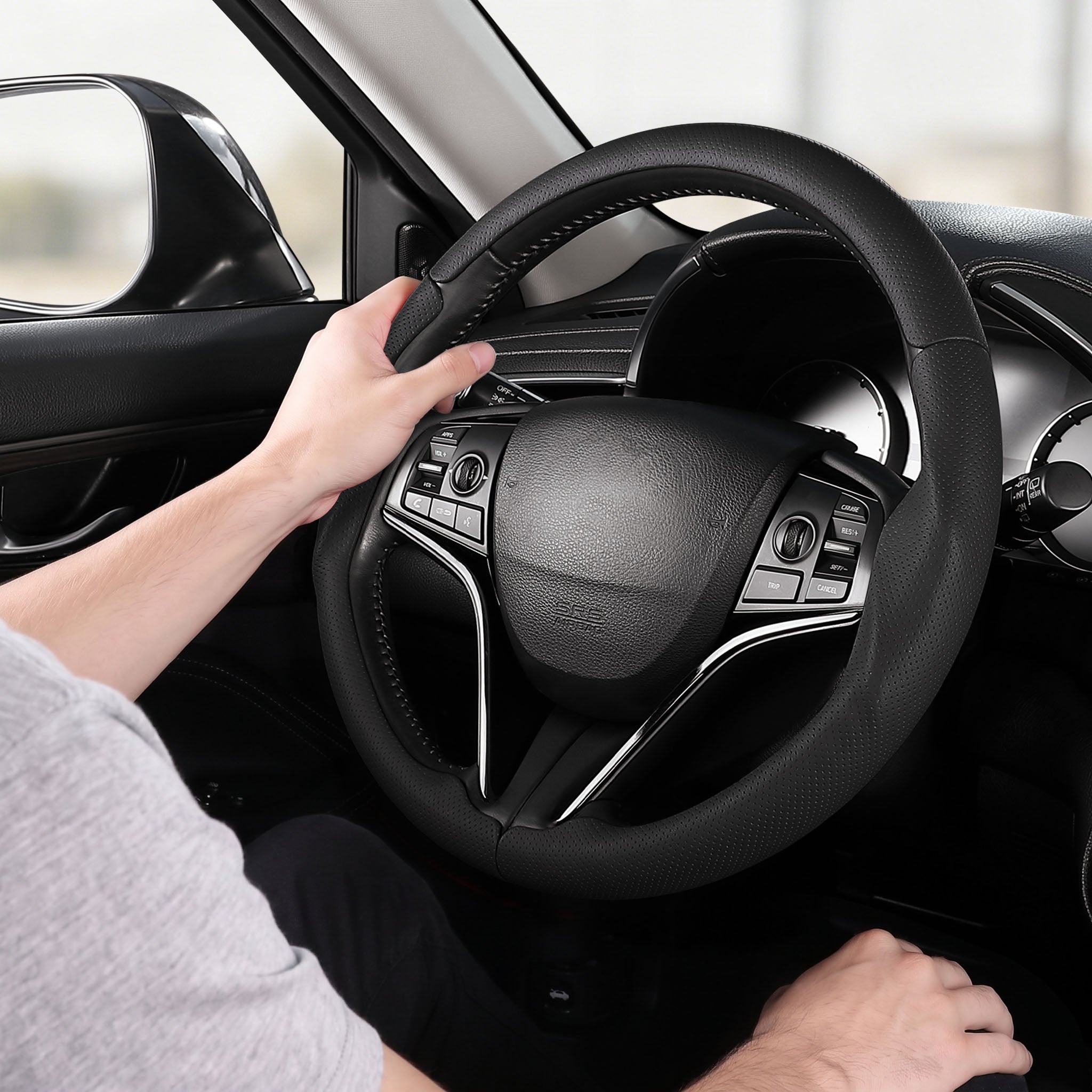 Installed view of black perforated leather 3-piece steering wheel cover for Honda Civic 2016-2021 & Clarity 2018-2021 with driver holding the wheel#color=black perforated leather
