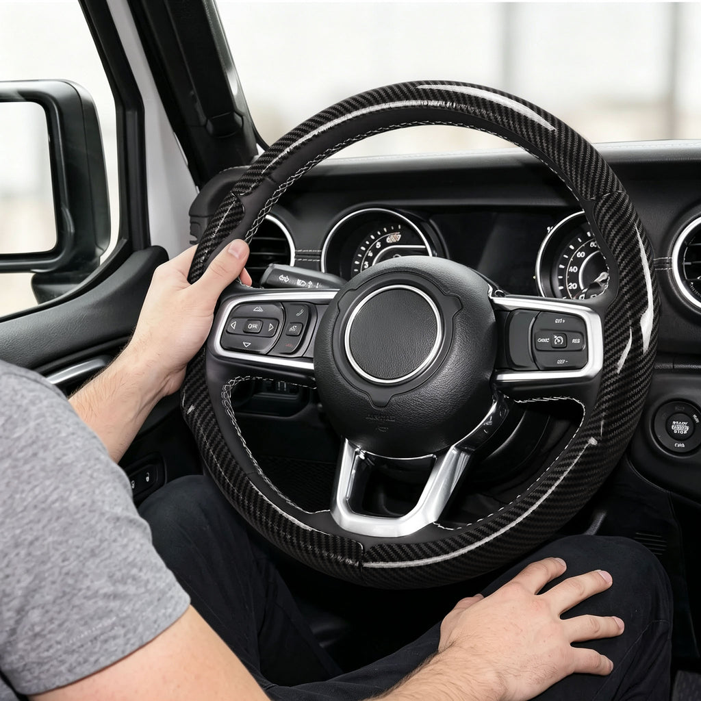 Installed view of glossy black carbon-fiber-style 3-piece steering wheel cover for Jeep Wrangler 2018-2026 with driver holding the wheel#color=glossy black