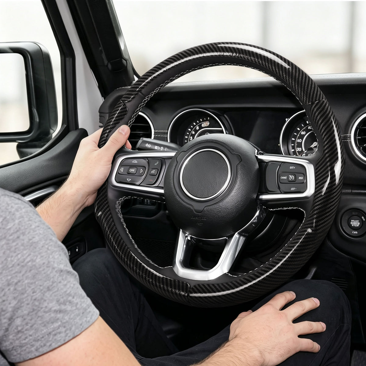 Installed view of glossy black carbon-fiber-style 3-piece steering wheel cover for Jeep Wrangler 2018-2026 with driver holding the wheel#color=glossy black