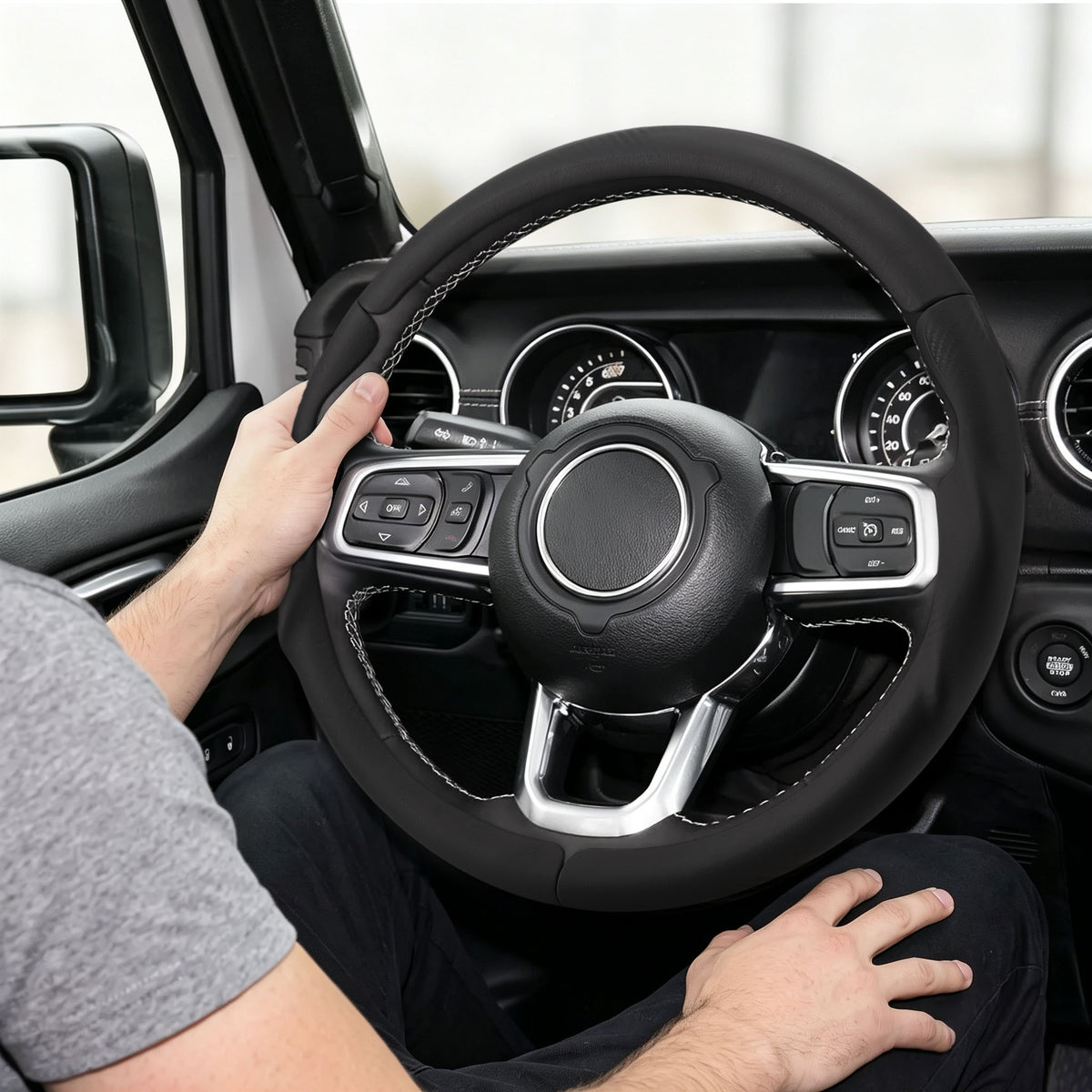 Installed view of black leather 3-piece steering wheel cover for Jeep Wrangler 2018-2026 with driver holding the wheel#color=black leather