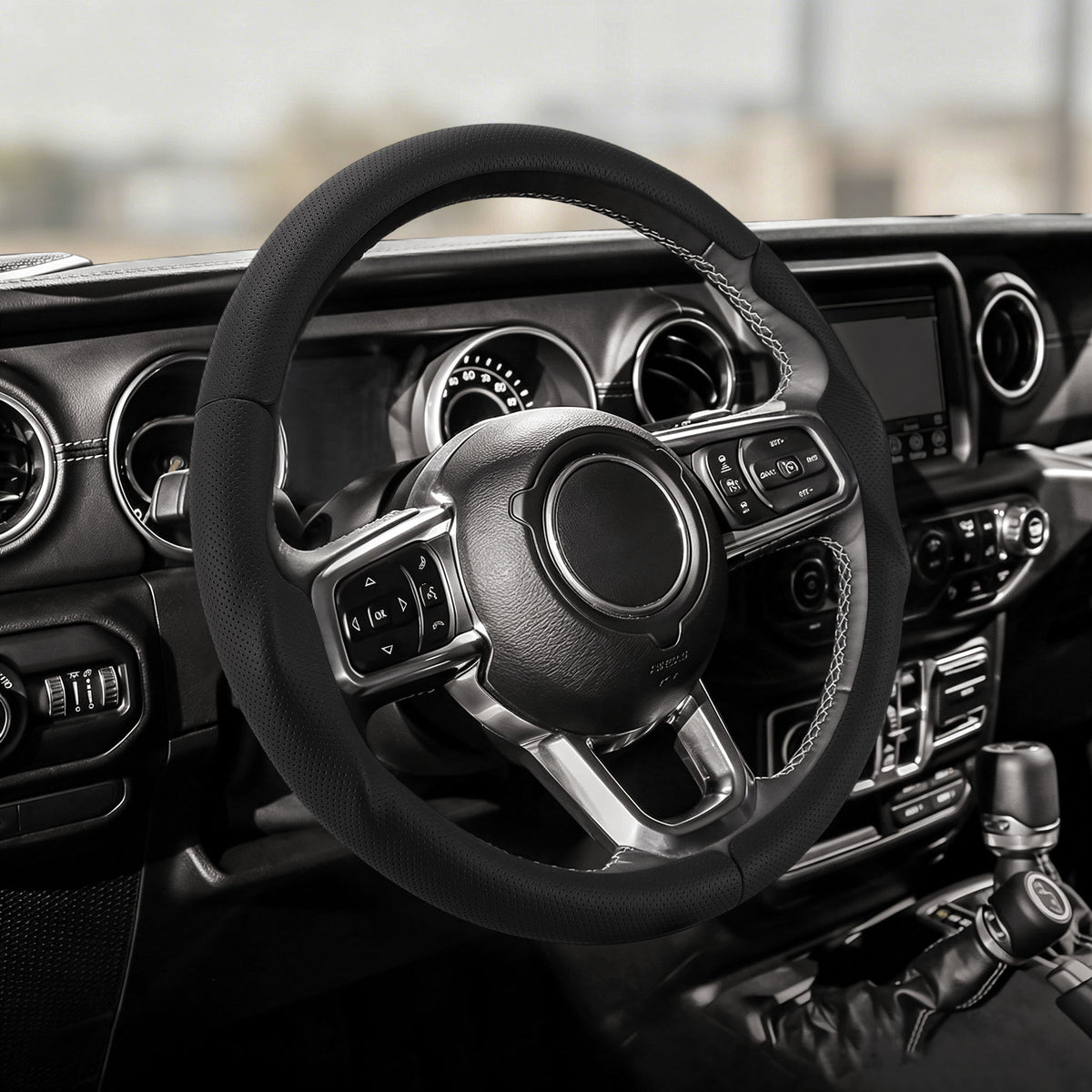 Cockpit view of black perforated leather 3-piece steering wheel cover for Jeep Wrangler 2018-2026