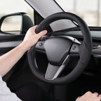 Installed view of black perforated leather 3-piece steering wheel cover for Tesla Model Y 2020-2024 with driver holding the wheel#Model=Model Y 2020-2024|color=black perforated leather