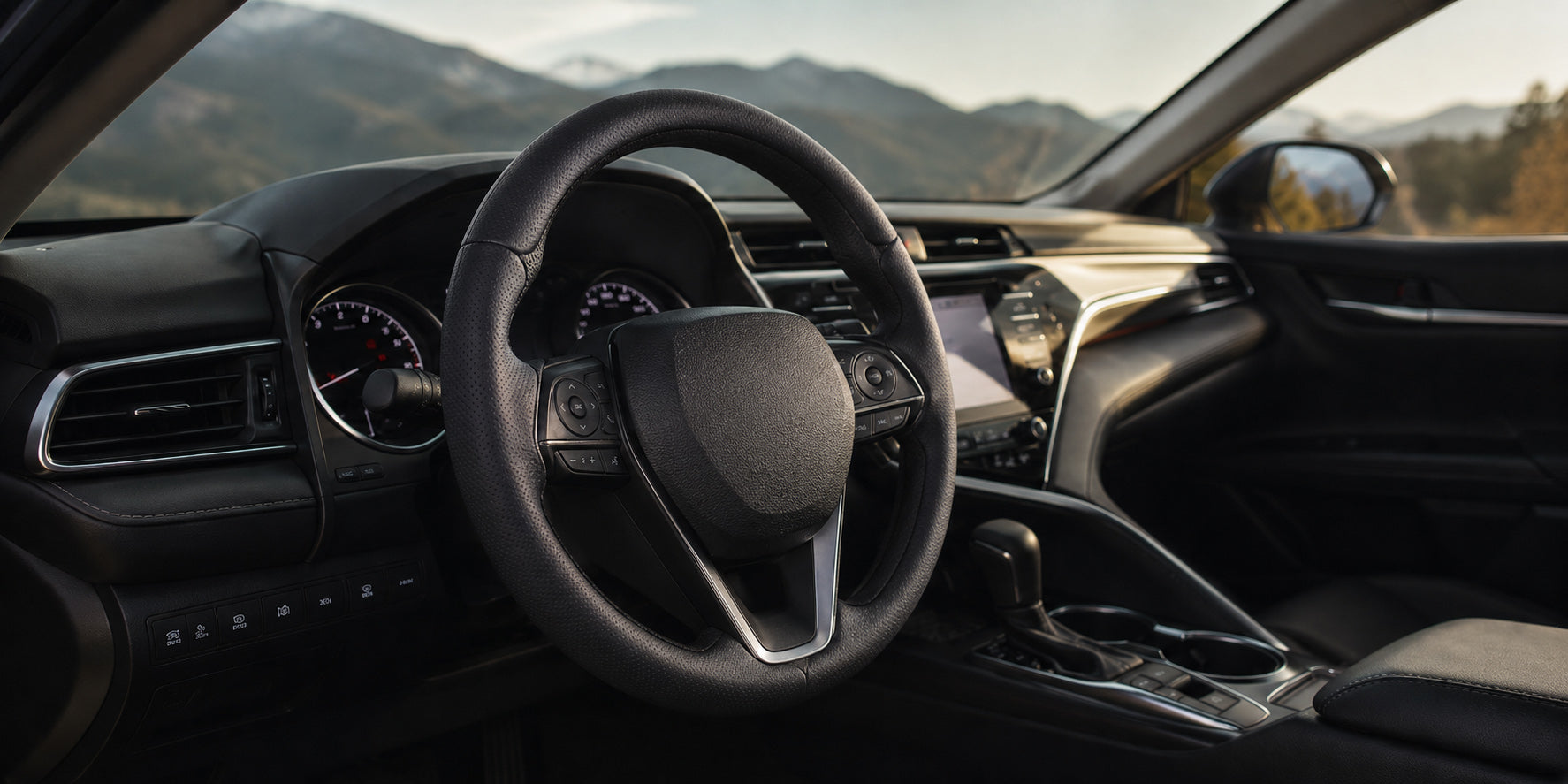 Car steering wheel cover collection featuring a black perforated leather cover installed in a Toyota Camry interior