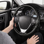 Installed view of matte black carbon-fiber-style 3-piece steering wheel cover for Toyota Corolla 2014-2019 with driver holding the wheel#color=matte black