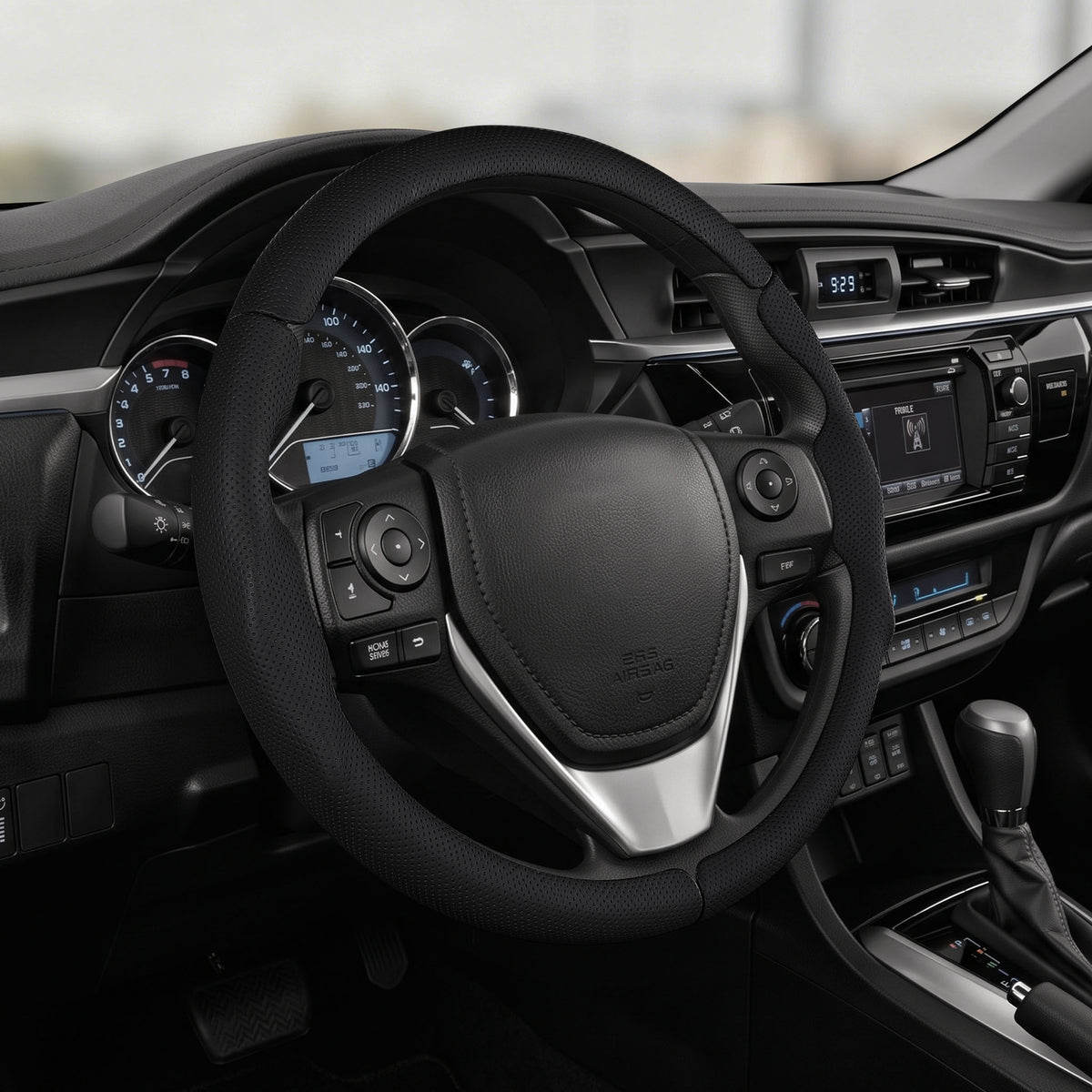 Cockpit view of black perforated leather 3-piece steering wheel cover for Toyota Corolla 2014-2019