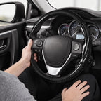 Installed view of glossy black carbon-fiber-style 3-piece steering wheel cover for Toyota RAV4 2013-2018 with driver holding the wheel#color=glossy black