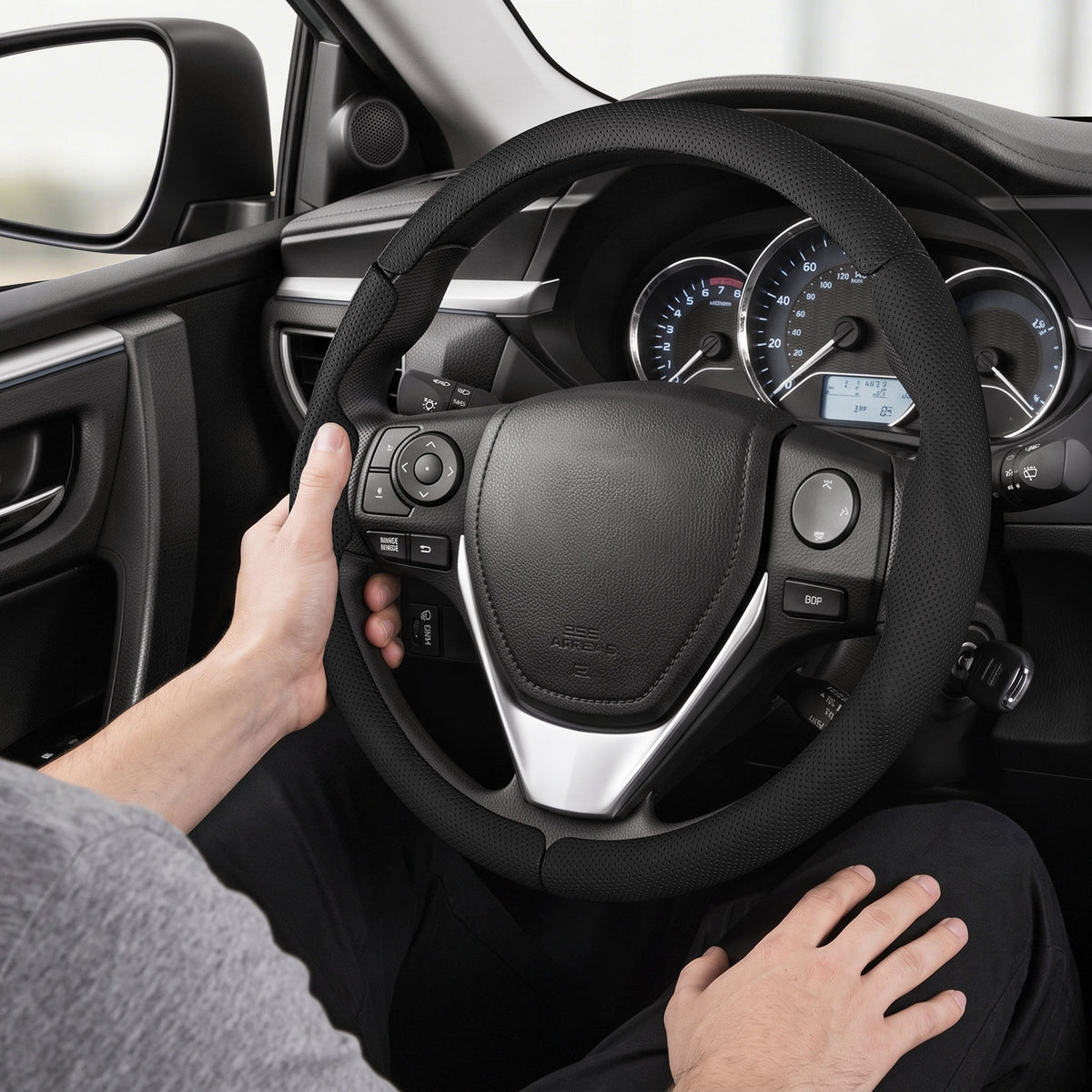 Installed view of black perforated leather 3-piece steering wheel cover for Toyota RAV4 2013-2018 with driver holding the wheel#color=black perforated leather