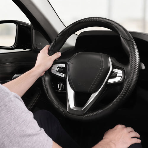 Installed view of matte black carbon-fiber-style 3-piece steering wheel cover for 14.5-15 Inch Wheels with driver holding the wheel#color=matte black
