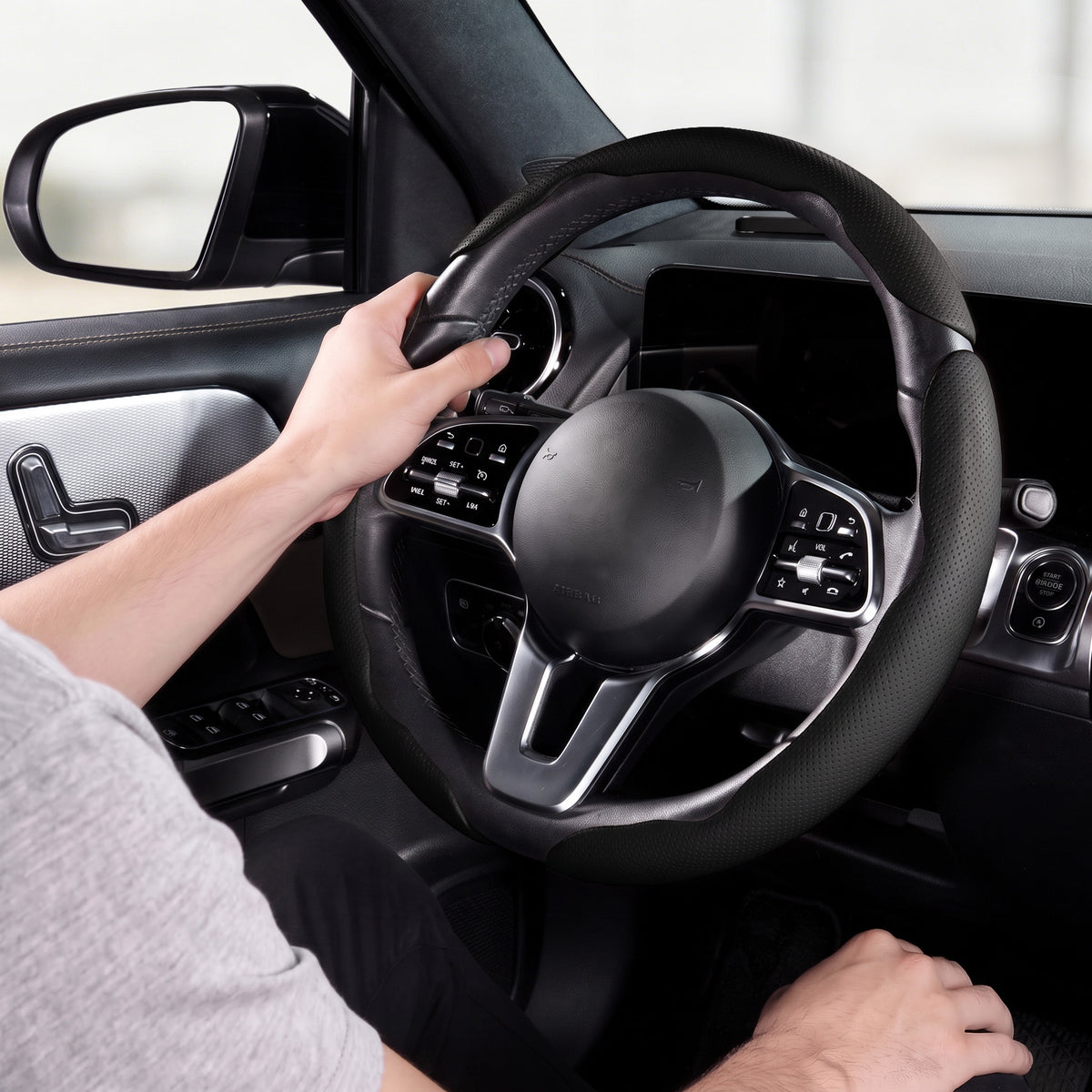 Installed view of black perforated leather 3-piece steering wheel cover for 14.5-15 Inch Wheels with driver holding the wheel#color=black perforated leather