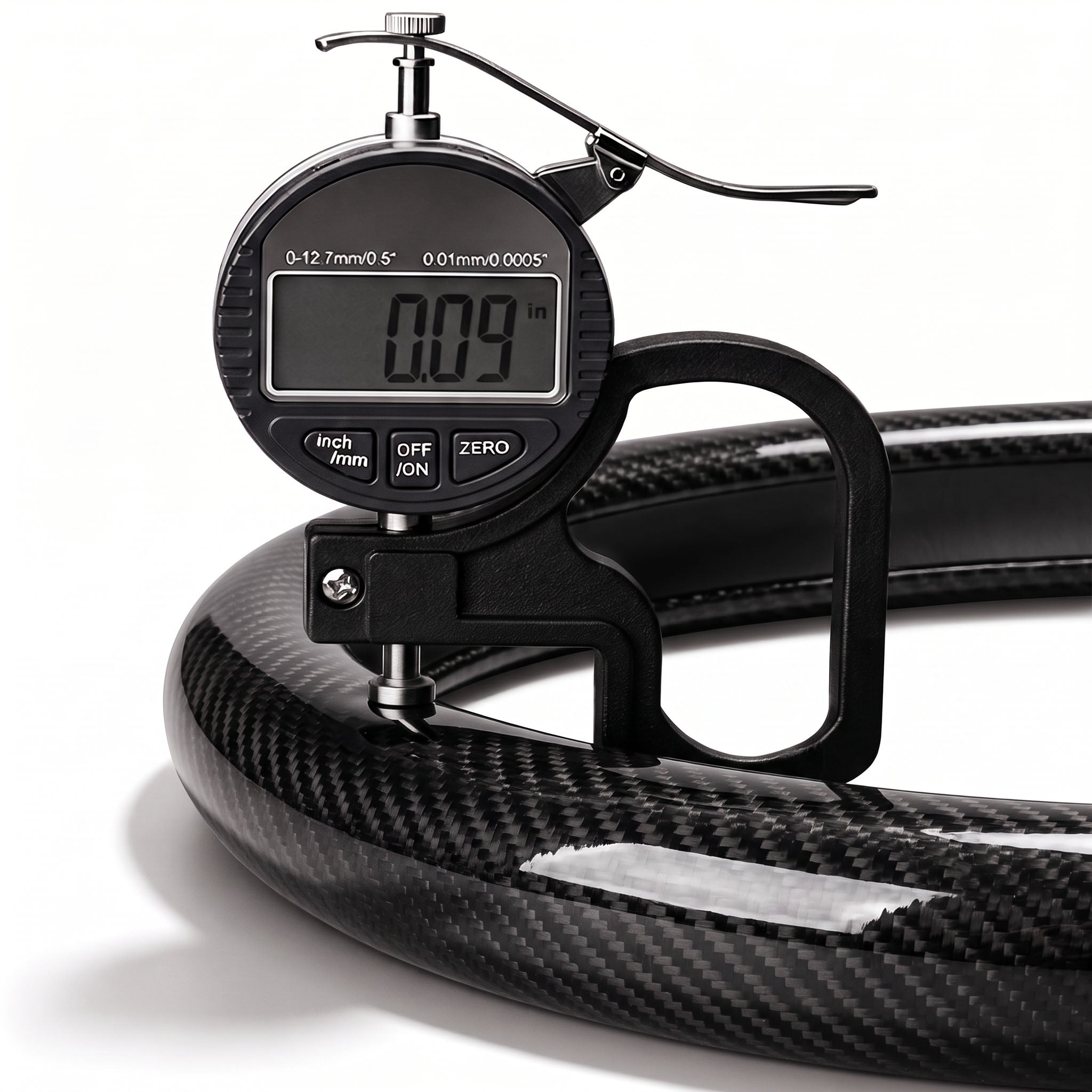 Digital thickness gauge showing the 0.09-inch ultra-slim profile of a glossy black carbon-fiber-style steering wheel cover#color=glossy black