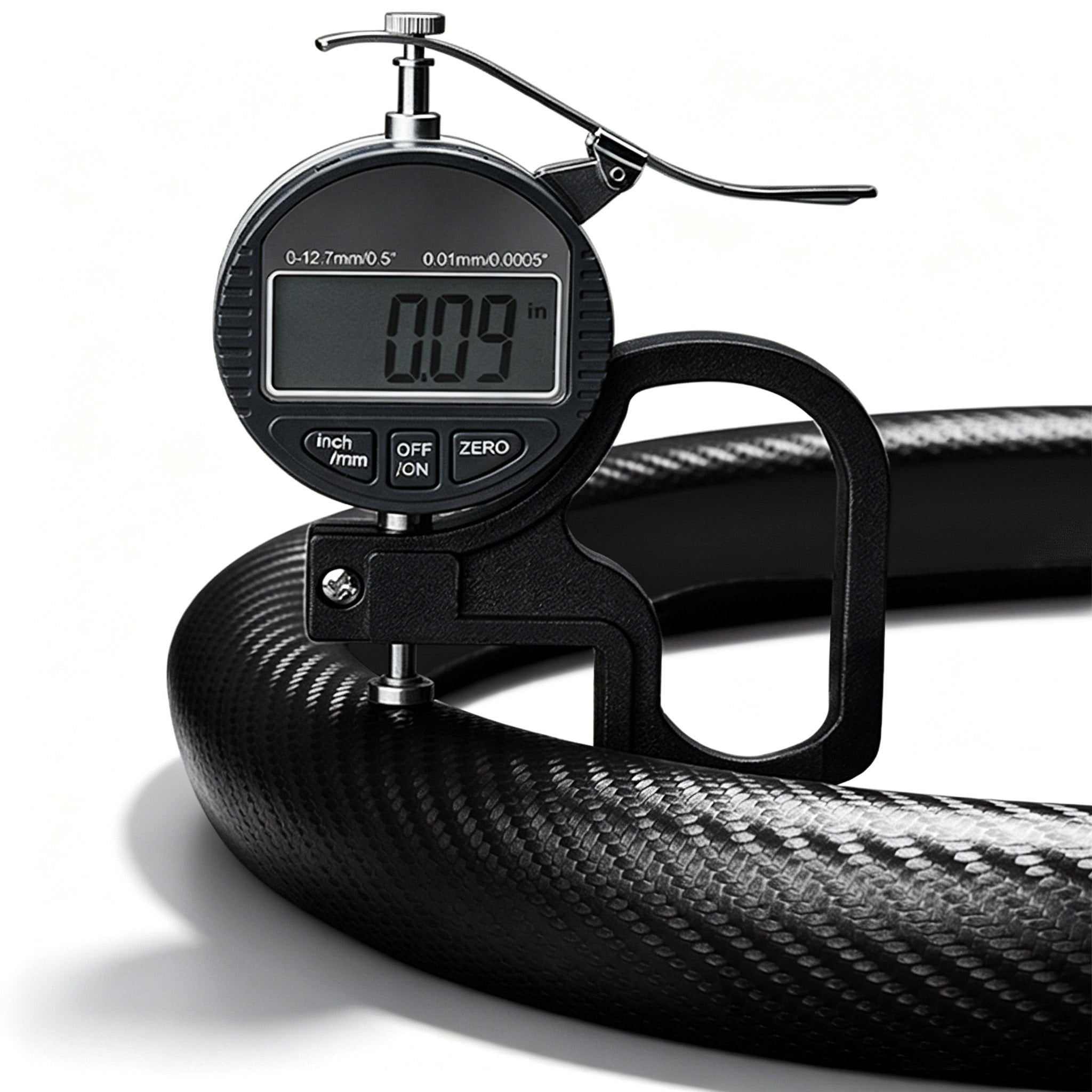 Digital thickness gauge showing the 0.09-inch ultra-slim profile of a matte black carbon-fiber-style steering wheel cover#color=matte black