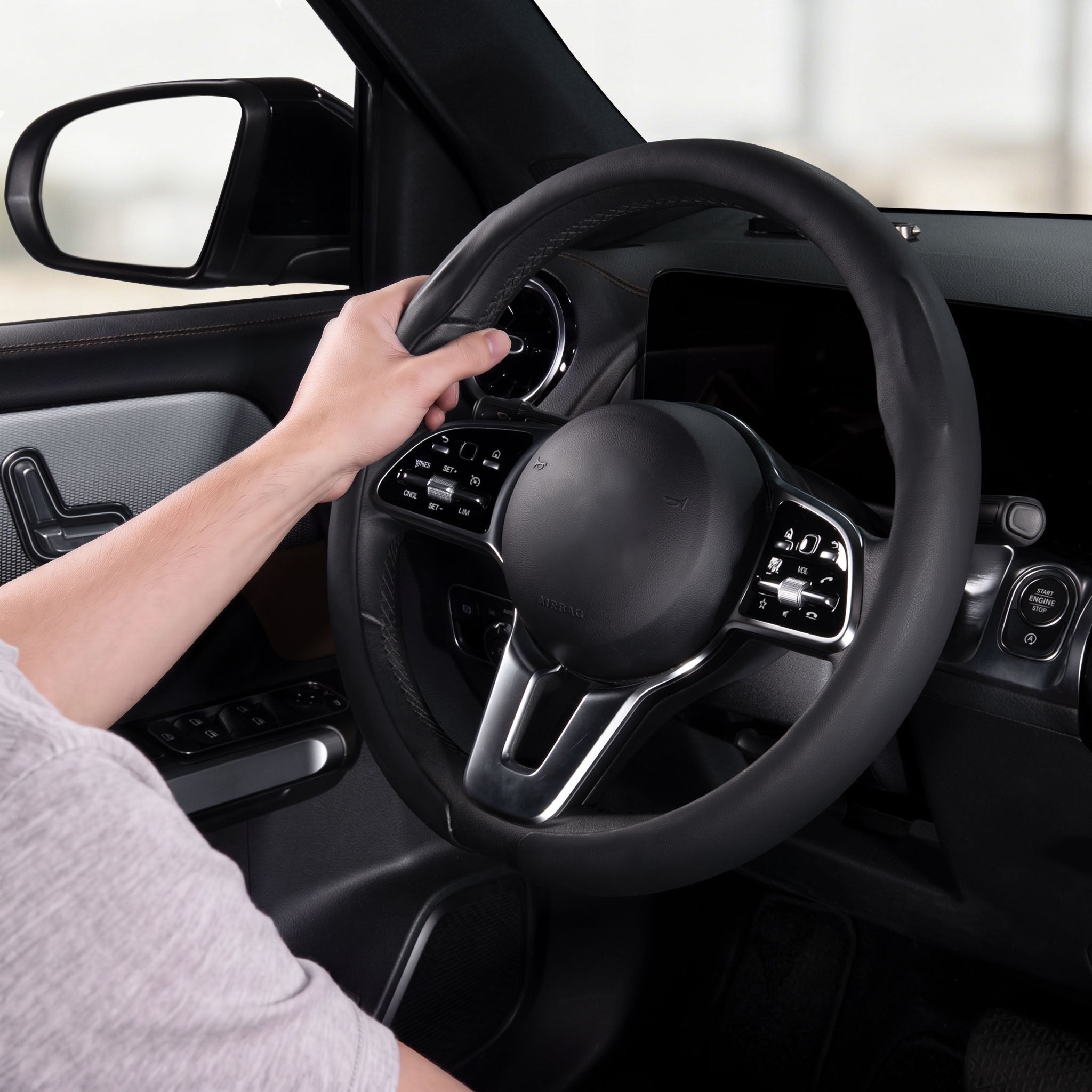 Installed view of black leather steering wheel cover for 14.5-15 Inch Wheels with driver holding the wheel#color=black leather