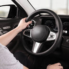 Installed view of black perforated leather steering wheel cover for 14.5-15 Inch Wheels with driver holding the wheel#color=black perforated leather