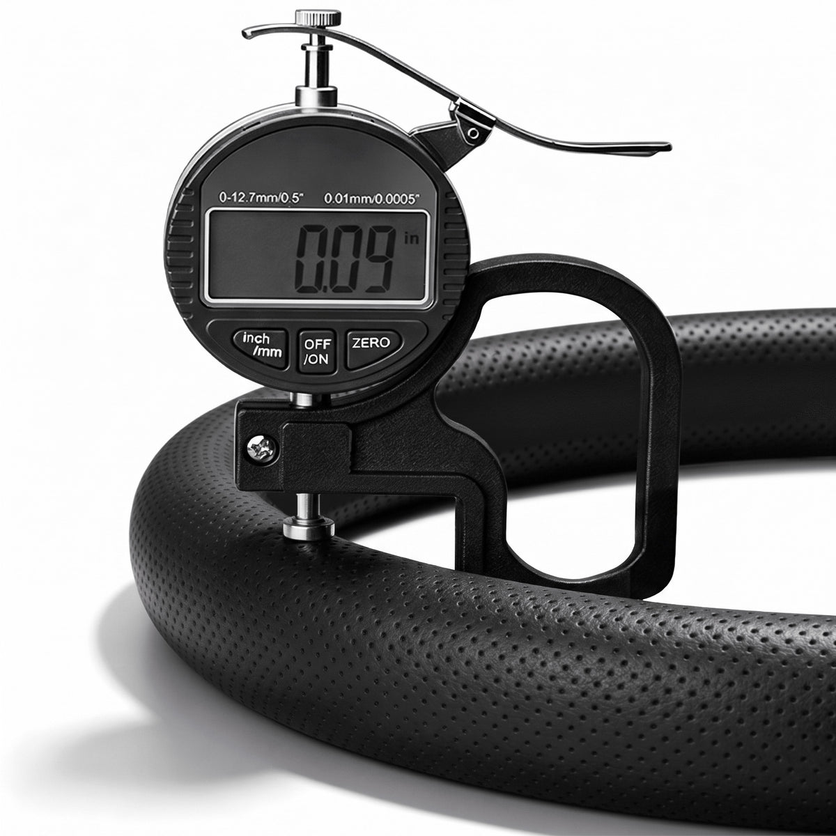 Digital thickness gauge showing the 0.09-inch ultra-slim profile of a black perforated leather steering wheel cover#color=black perforated leather